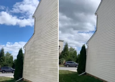 A house’s siding before and after cleaning; left side is dirty, right side is clean, under cloudy skies.