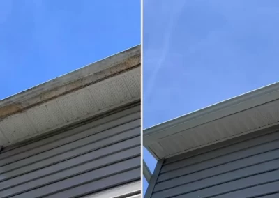Side-by-side view of a house’s eaves: left side dirty, right side cleaned, both under a blue sky.